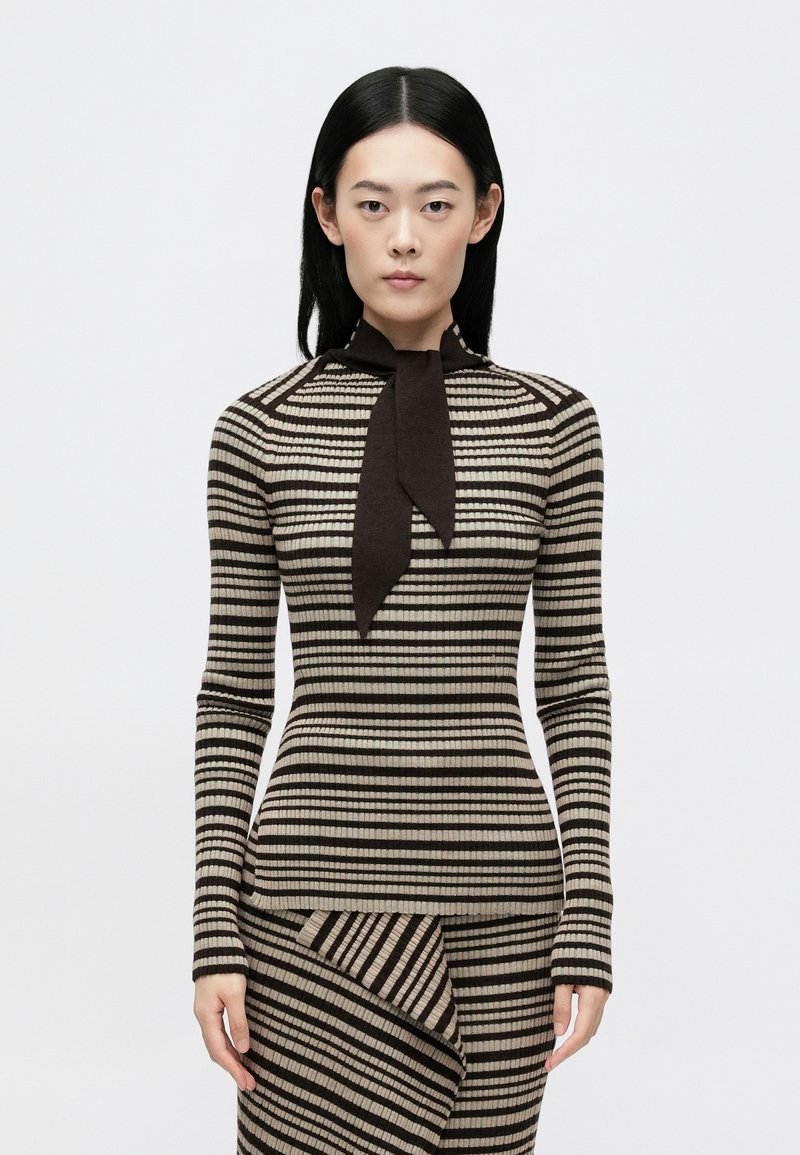 Sweater riscado com gola alta e detalhe de laço, apresentando mangas longas e bandas horizontais em tecido de malha castanho e bege claro.