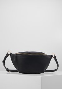 Musta nahkavyölaukku pyöreällä muotoilulla, kultaisella vetoketjulla ja säädettävällä hihnalla. Tasaisen sileä tekstuuri ja minimalistinen muotoilu.