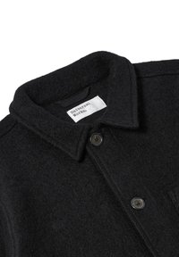 Giacca nera in lana con colletto, dotata di due bottoni e una tasca sul petto, in tessuto testurizzato, con etichetta "Universal Works."