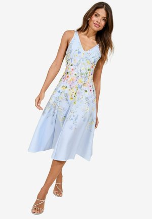 Bloemen midi-jurk in lichtblauwe stof. Heeft een V-hals, een aansluitende bodice en een uitlopende rok met kleurrijke bloemenpatronen.