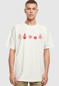Hvid bomulds t-shirt med røde, ferieinspirerede grafikker: en krus, snemand, snefnug, gave og juletræ, med en afslappet pasform.