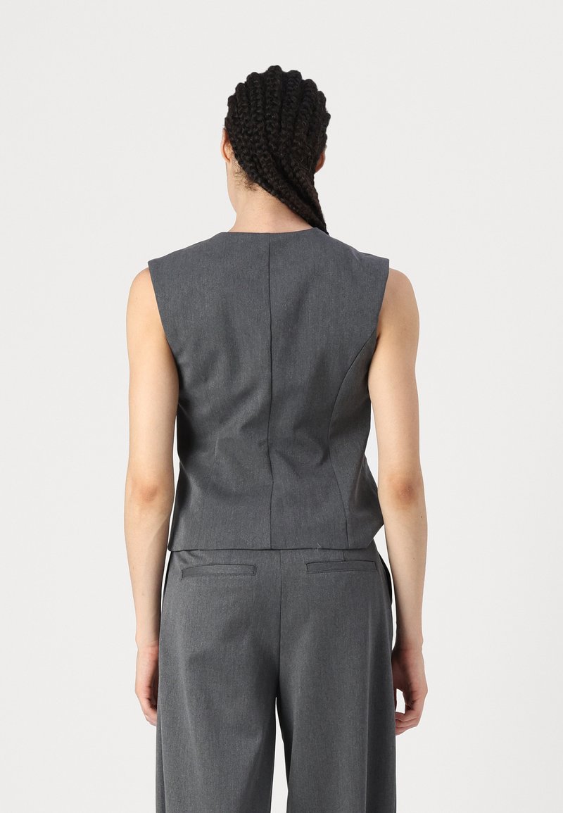 Grau ärmelloses Top mit strukturiertem Design, ausgestattet mit hohem Kragen und tailliertem Rücken, aus strukturiertem Stoff gefertigt.
