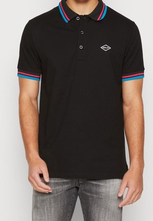Polo noir avec un col et des poignets rayés en bleu vif et rose, arborant un petit logo blanc sur la poitrine.