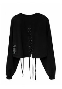 Sudadera recortada negra con un diseño de espalda con cordones y ojales, mangas largas y textura suave. Incluye una etiqueta en el lado.