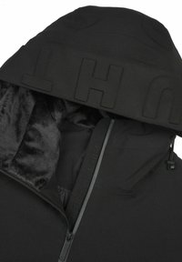 Veste à capuche noire en tissu texturé. Dotée d'une doublure en fausse fourrure douce, d'un logo proéminent sur la capuche et d'une fermeture éclair.