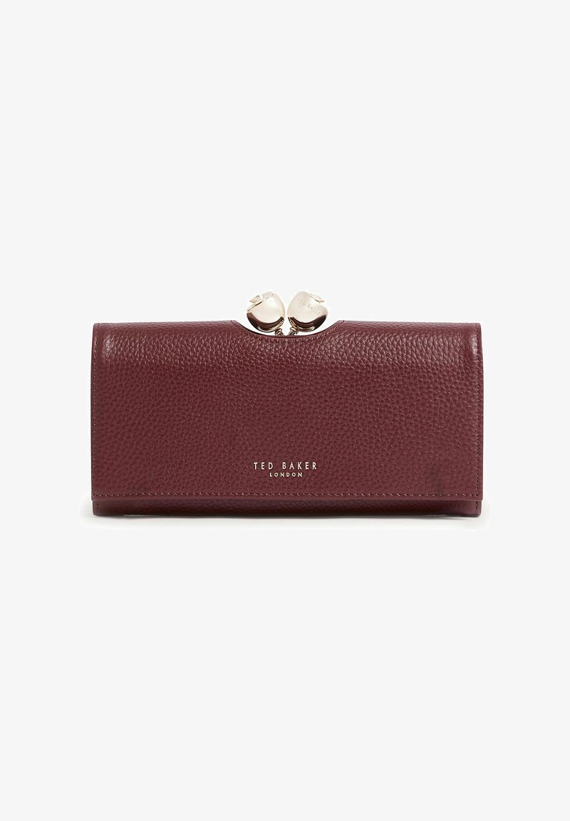 Portefeuille en cuir texturé bordeaux avec fermoir argenté en forme de nœuds, logo « Ted Baker London » embossé en argent sur le devant.