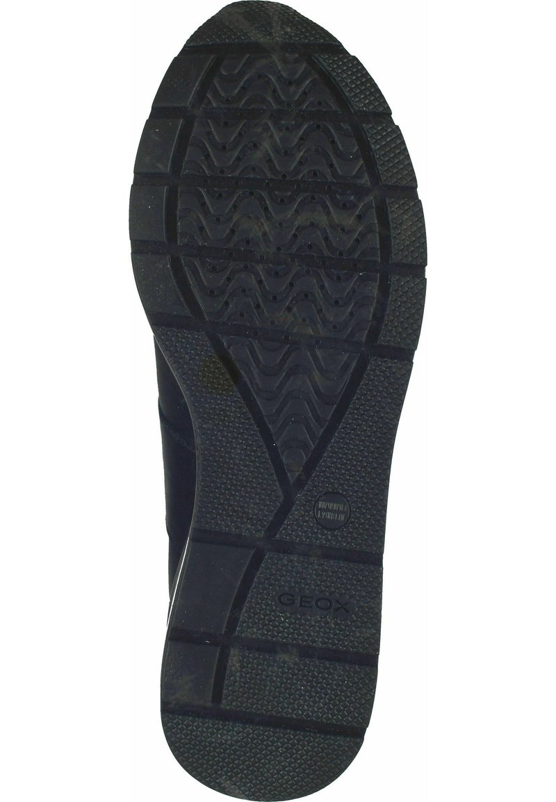 Semelle en caoutchouc noir avec grip texturé, présentant des motifs de bande de roulement ondulés et droits, ainsi que de petits trous de ventilation. Logo 'GEOX' imprimé visible.