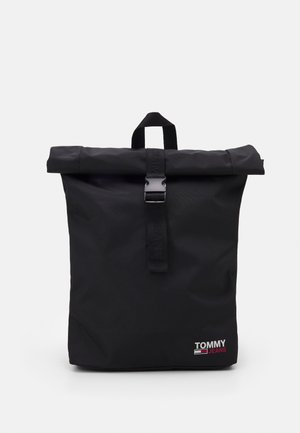 Czarny plecak typu roll-top z przednim zapięciem na klamrę i logo "Tommy Jeans" w białym i czerwonym kolorze w dolnym prawym rogu.