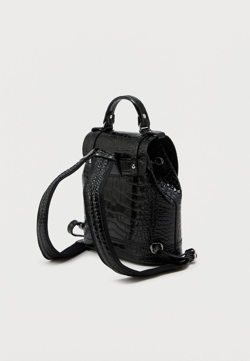 Zaino in ecopelle di coccodrillo nero con superficie testurizzata, doppi manici superiori, spallacci regolabili e chiusura a pattina con dettagli in metallo.