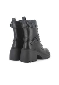 Botines negros con un acabado liso similar al cuero, tacones altos y gruesos, cordones prominentes y hebillas decorativas en los laterales.