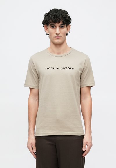 Beige short-sleeve t-shirt made of soft fabric with a crew neck, featuring a printed black logo "TIGER OF SWEDEN" across the chest.