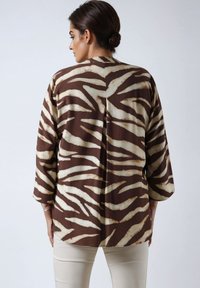 Brown and cream striped kimono jacket with three-quarter sleeves, a relaxed fit, and a subtle texture, designed for layering.