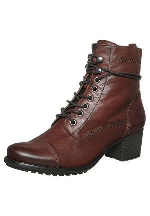 Bottine en cuir marron avec laçage devant, couture décorative, bout rond et talon bloc superposé.