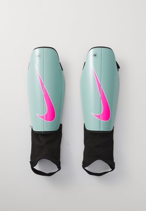 Parastinchi Nike, con guscio in plastica di un blu teal chiaro, grande logo swoosh rosa, e con maniche elastiche nere alla base per un attacco sicuro.