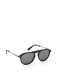 Lunettes de soleil aviator à monture noire avec verres polarisés foncés et branches métalliques fines, posées sur un fond blanc.