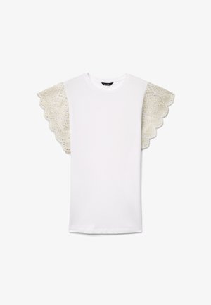 T-shirt blanc à manches courtes avec col rond et larges détails en dentelle festonnée sur les manches présentant des motifs floraux élaborés.