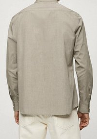 Lichtgrijze langslambre shirt, met textuurstof, met knoopmanchetten en een kraag. De achterkant toont een rechte snit en minimale naaddetails.