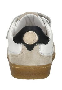 Witte sneaker met een beige suède hiel, zwarte accent aan de achterkant en een ronde logo patch. Platte rubberen zool met een gestructureerde grip.
