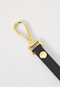 Black leather strap with gold metal snap hook, featuring a round gold rivet and stitched detailing on the strap.