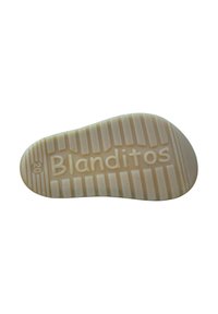 Suela de zapato antideslizante en beige con un patrón texturizado. Presenta el nombre de la marca "Blanditos" grabado cerca del talón. Bordes suaves y redondeados.