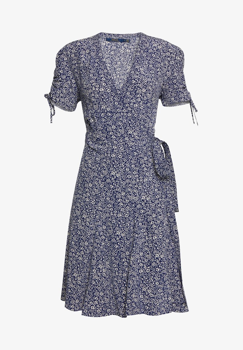 Robe portefeuille bleu marine avec petits motifs floraux blancs, manches courtes avec liens, col en V et ceinture à nouer sur le côté de la taille.