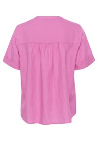 Rosa kortärmad skjorta gjord av mjukt tyg, med en avslappnad passform, rundad fåll och subtilt samlad detalj vid ryggen.