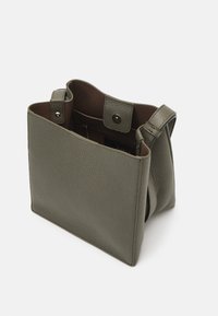 Green textured leather handbag with a structured design, open top, inner pocket, and subtle metal hardware.