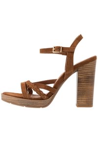 Brown suede high-heeled sandal with braided front straps, ankle strap with gold buckle, and wood-textured block heel.