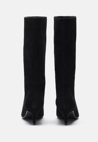 Bottes noires en daim, montantes jusqu'au genou, avec une silhouette épurée, un bout pointu et un talon fin. Texture subtile avec une finition lisse.