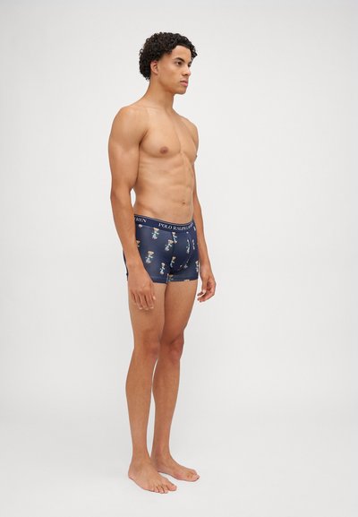 Calções de boxe em azul-marinho com padrões coloridos, apresentando uma cintura elástica com marca, tecido macio e um design ajustado.