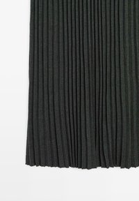 Tissu maille côtelée gris foncé avec plis verticaux, présenté en gros plan sur fond blanc.