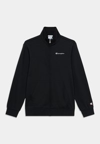 Μαύρο τζάκετ με φερμουάρ κατασκευασμένο από λείο ύφασμα, με ψηλό γιακά, δύο τσέπες μπροστά και μικρό λευκό λογότυπο στο αριστερό στήθος.