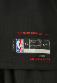 Black NBA Swingman jersey with perforated texture. Features red text, a label with logo, size 44, and "City Edition" tag.