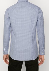 Camisa de manga larga con cuadros azules y blancos, puños con botones, corte entallado, con una textura de tela lisa y un diseño de cuello clásico.