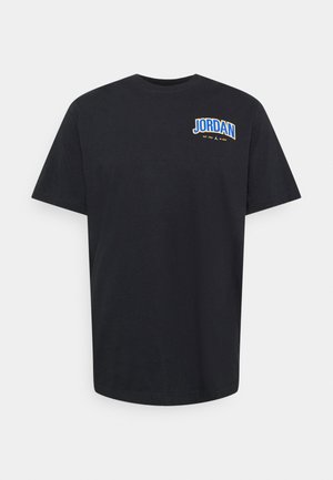 Czarny T-shirt z krótkim rękawem z małym napisem "JORDAN" w kolorze niebieskim i żółtym na lewej piersi, zawierający "EST. 1985" oraz logo Nike.