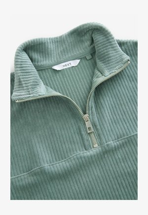Zeleni korduroj pulover s četvrtastim zipom i rebrastom teksturom, s metalnim patentnim zatvaračem i ovratnikom, označen "NEXT" iznutra.