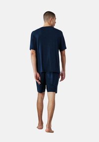 Conjunto de ropa de estar en azul marino que incluye una camiseta de manga corta y pantalones cortos. Tela suave con un corte relajado, que muestra un diseño simple y clásico.