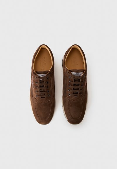 Un paio di sneakers in suede marrone con lacci, foderate in beige e con il brand sull'insole, posizionate affiancate su uno sfondo bianco.