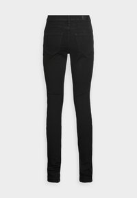 Black skinny jeans with a smooth texture, featuring a classic five-pocket design and a mid-rise waistband, seen from the back.
