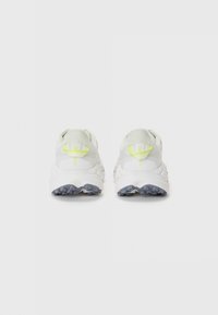 Weiße Sportschuhe mit einem strukturierten Mesh-Obermaterial, einer hinteren Zuglasche in Neon-Gelb und einer gepolsterten weißen Zwischensohle mit einer robusten grauen Laufsohle.