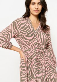 Knopfkleid in rosa und olivgrünem Zebra-Print. Besitzt einen lockeren Schnitt, lange Ärmel und eine taillierte Taille mit einem Bindeband.