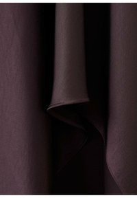 Tmavě fialová látka s jemnými záhyby a hladkou texturou, zobrazující vrstvený záhyb s viditelným šitím podél okraje.