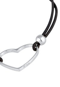 Hjärtpendig i sterlingsilver på ett svart läderband, med en polerad yta och en rund silverpärla som accent.