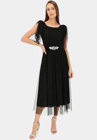 Czarna sukienka o swobodnym kroju, z tiulowymi rękawami i dekoracyjnym paskiem z kwiatowymi akcentami. Długość do kolan, miękka tekstura.