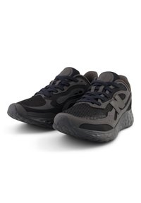 Athletic shoes in black and dark gray mesh with textured overlays, featuring a cushioned sole and contrasting laces. Notable "N" logo detail.