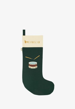 Žalias Kalėdų kojines audinys su kreminiu kraštu, vaizduojantis būgną su būgnininkų lazdomis, ir prekės ženklas auksinėmis raidėmis.