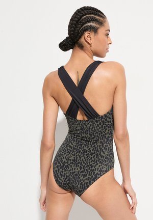 Maillot de bain noir et olive à motifs avec un design dos croisé et des bretelles larges, mettant en valeur une texture lisse et une silhouette ajustée.