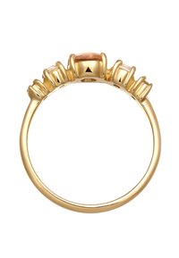 Guldring med en central bärnsten omgiven av två mindre klara stenar, med en polerad yta och slät band.