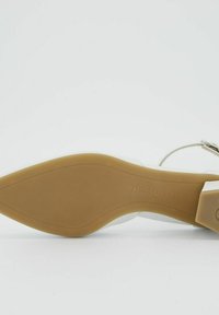 Beeži kõrge kontsaga king, millel on elegantne disain, sile valge ülaserv ja tekstuuriga beež tallaosa, millel on silt "paul green".