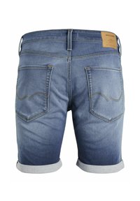 Pantalones cortos de mezclilla en un degradado de azul claro a oscuro, con dobladillos enrollados, dos bolsillos traseros con costuras curvas y una etiqueta de cuero en la cinturilla.